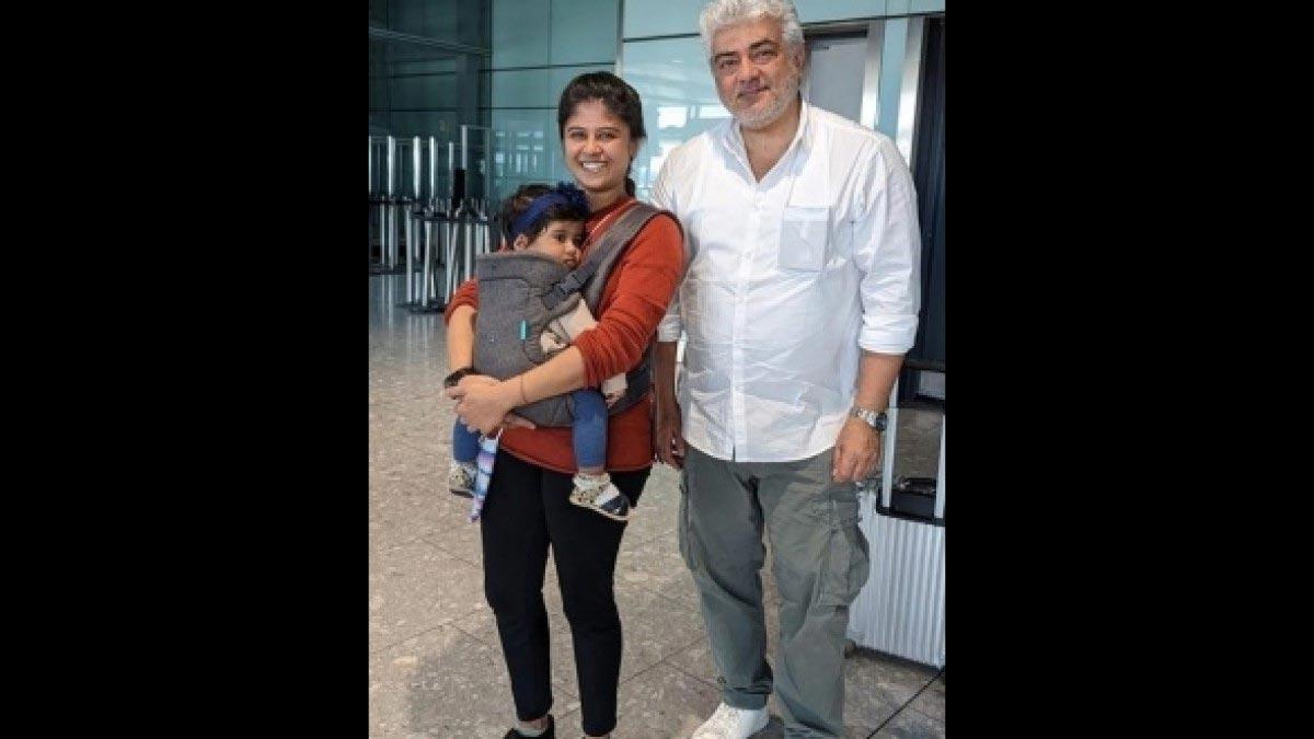 Ajith helps a woman with her toddler at the airport