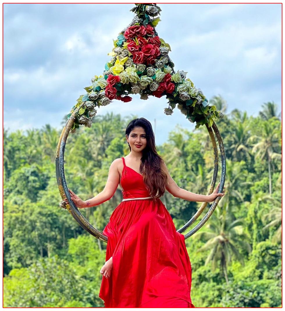 Iswarya seated gracefully on a swing adorned with vibrant flowers