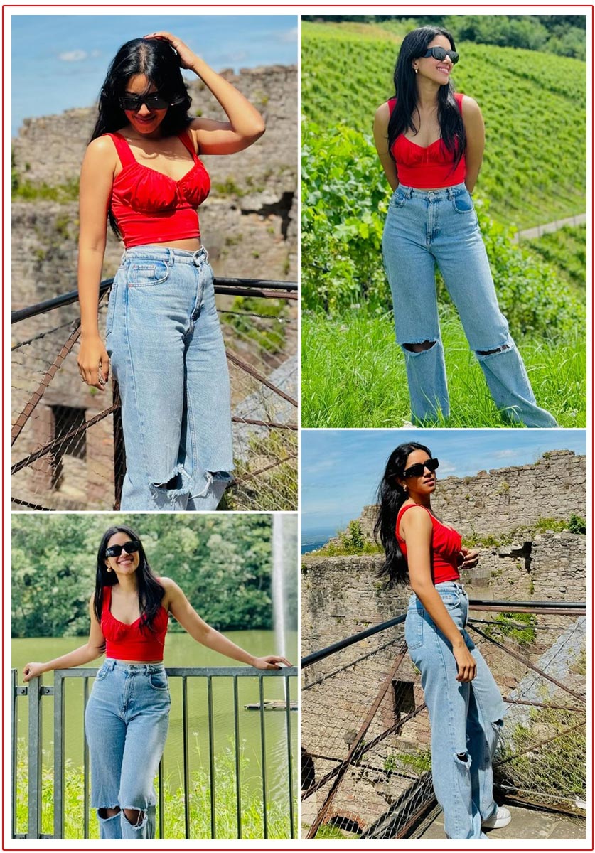 Mirnalini Ravi  Dressed in a vibrant red crop top paired with distressed blue jeans